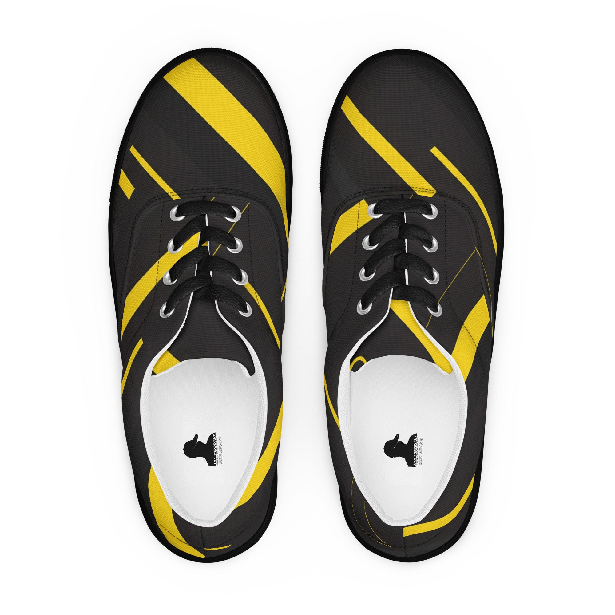 Produktbild von majorprint: Ein Paar Canvas-Sneaker aus der Vogelperspektive fotografiert. Das schwarze Obermaterial zeigt ein All-over-Design mit dynamischen, unterschiedlich breiten Streifen und Linienstrukturen in hellem Gelb. Die Schuhe besitzen schwarze Schnürsenkel, silberne Metallösen und ein quadratisches Logo-Label auf den weißen Innensohlen.