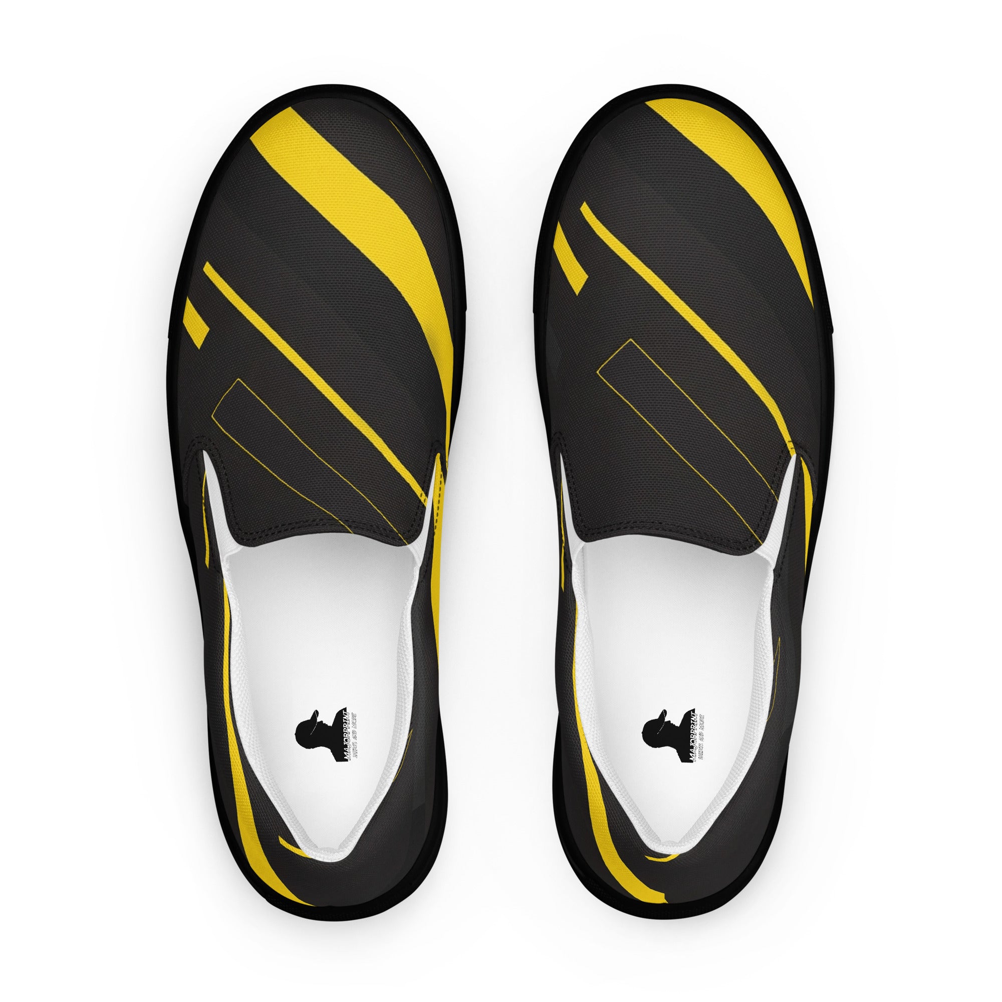 Produktbild von majorprint: Slip-On-Schuhe aus Canvas aus der Vogelperspektive. Das schwarze Obermaterial zeigt ein All-over-Design mit dynamischen, diagonal verlaufenden gelben Streifen und feinen gelben Linienstrukturen. Die Slipper verfügen über weiße elastische Einsätze, eine flache schwarze Sohle und ein quadratisches Logo-Label auf den weißen Innensohlen.