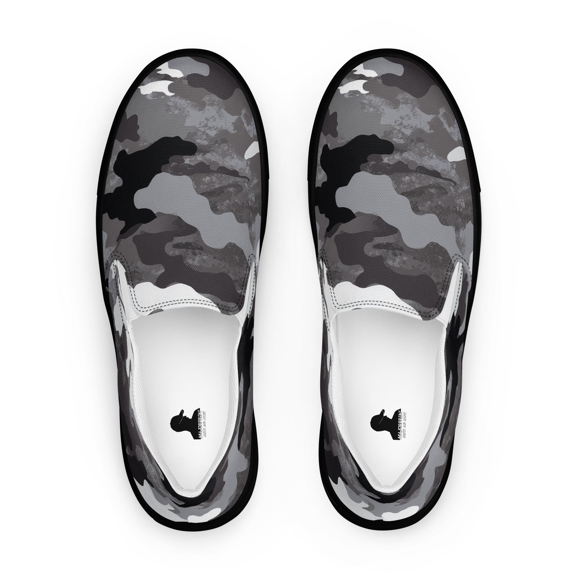 Ein Paar Slip-On-Sneaker von majorprint in der Draufsicht mit einem Camouflage-Muster in Schwarz, Grau und Weiß, freigestellt vor weißem Hintergrund.